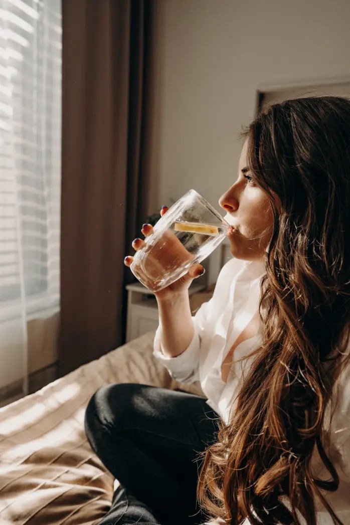 millennial woman drinks water for self care morning practice