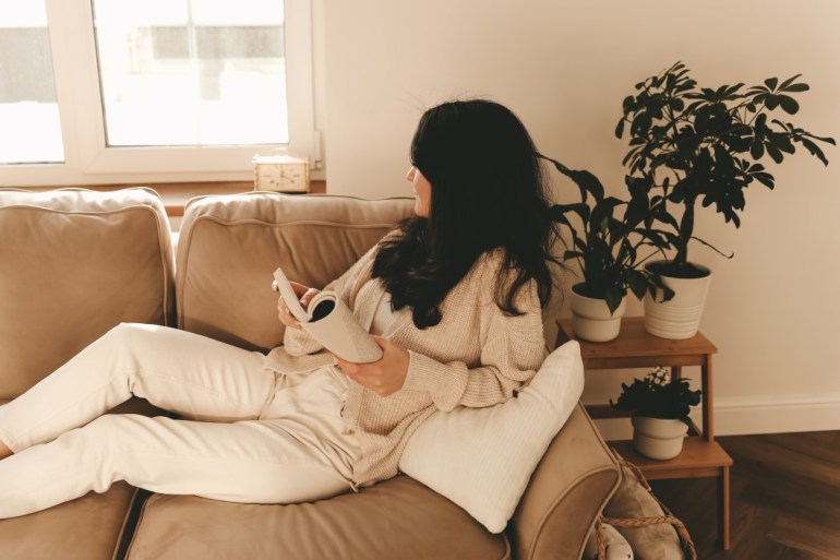 reading a fiction book on couch