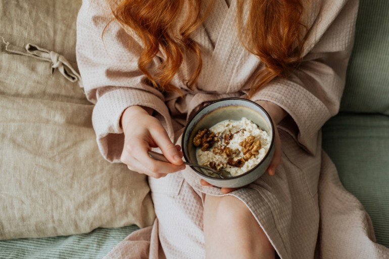 girl in robe eating breakfast on sunday morning